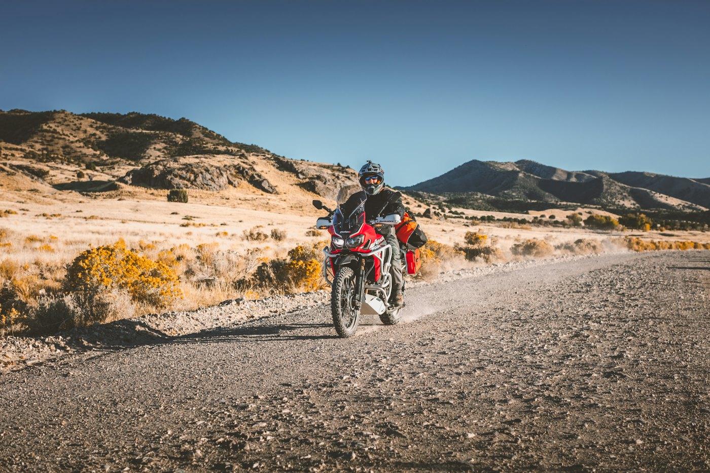 Rider on a dusty road through dry hills
