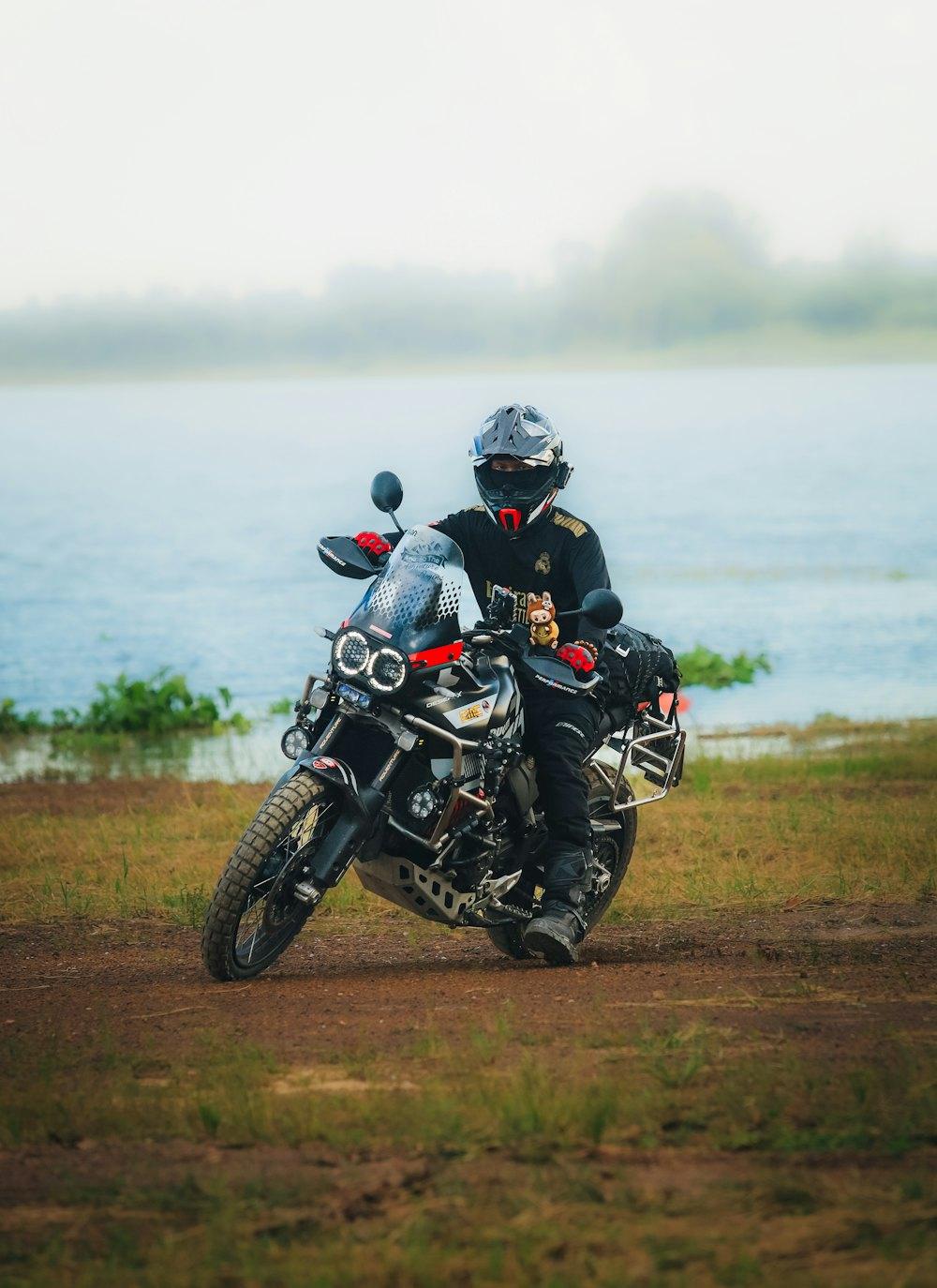 Rider on an adventure bike beside a misty lake